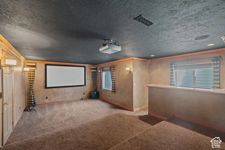 Built-in projector and large screen, tiered carpeted flooring, decorative wall sconces, integrated ceiling speaker, and a window with blinds