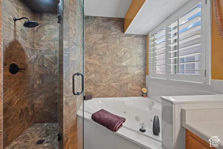 Tiled shower enclosure with dark bronze fixtures and a glass door