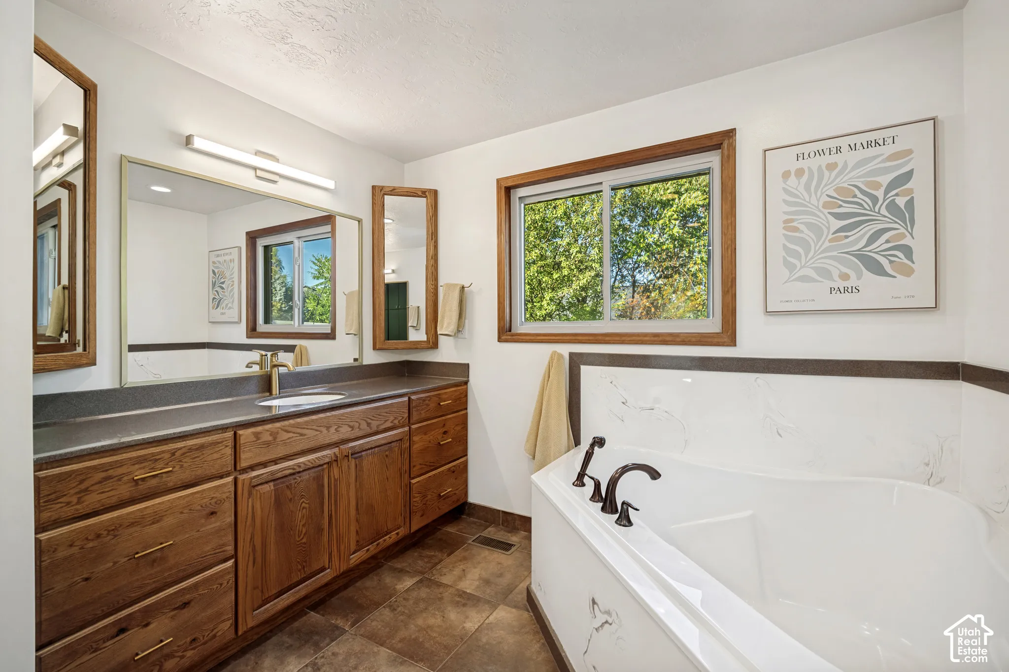Primary bathroom with shower, freestanding tub, and dual vanities