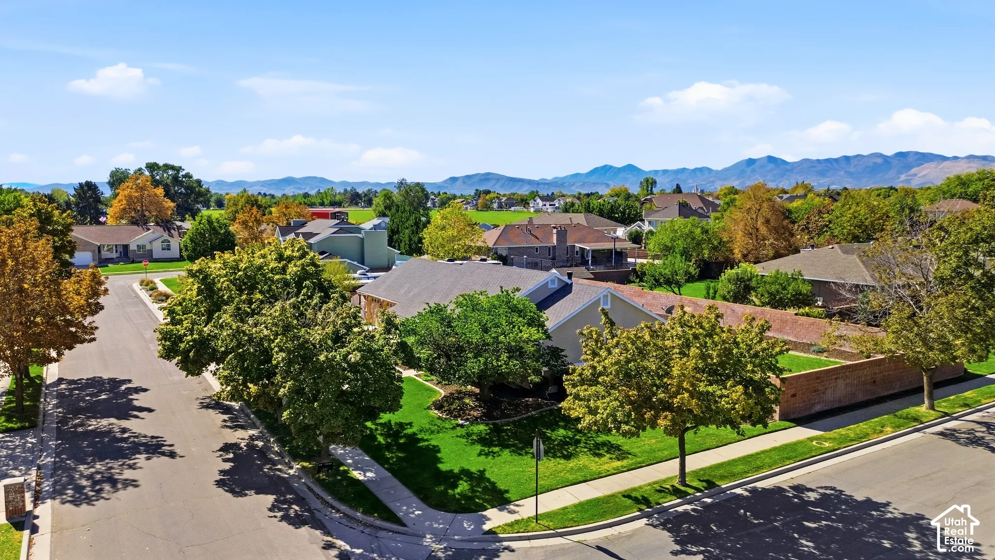 Residential neighborhood with mature trees, paved streets, and sidewalks