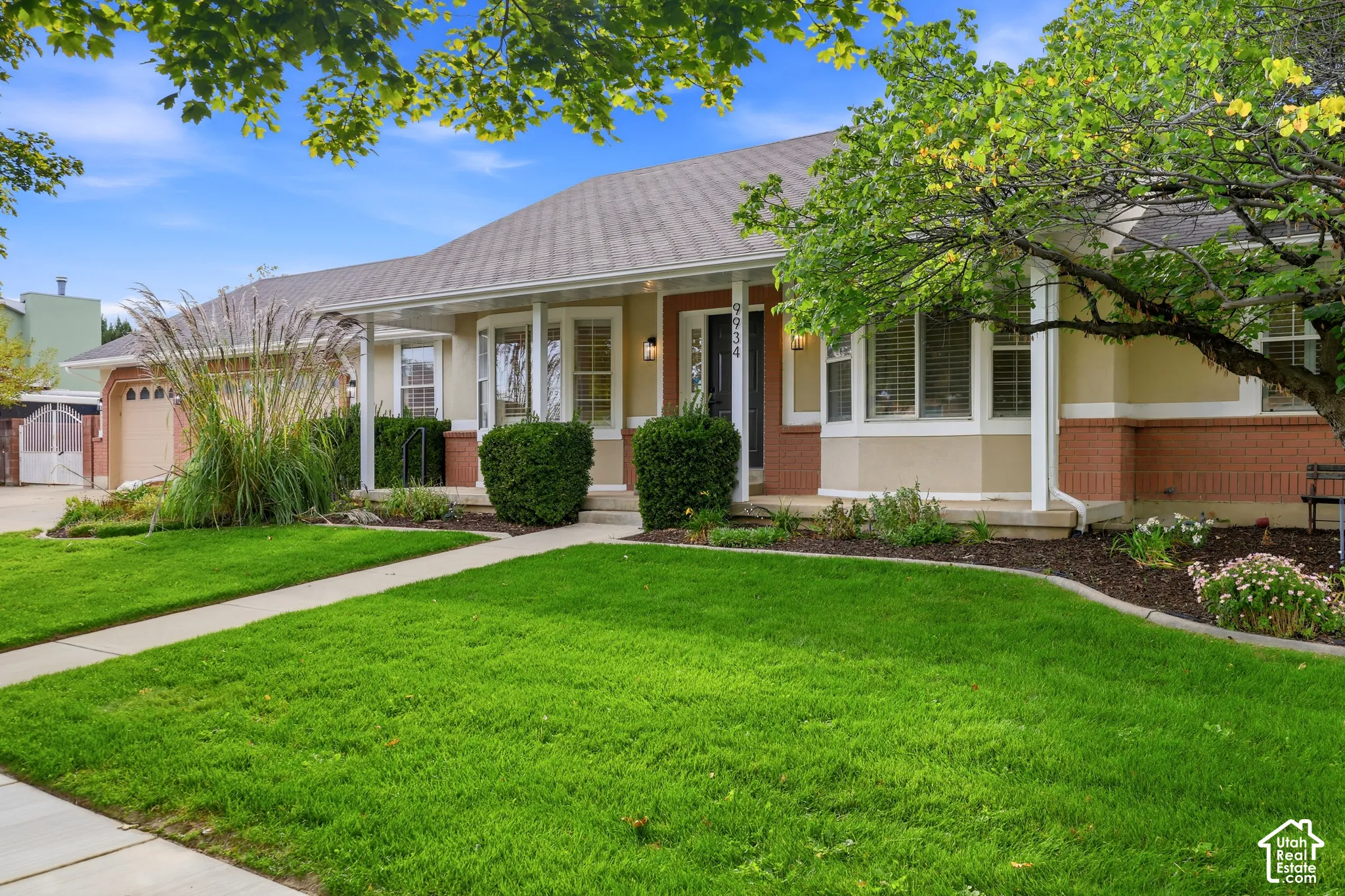 Front exterior with a composition shingle roof, brick and stucco siding, and bay windows