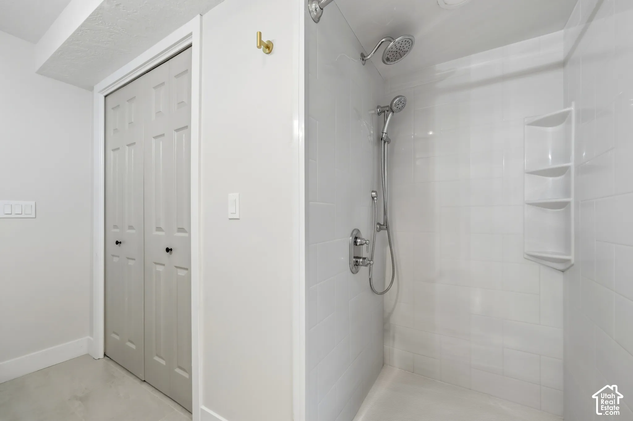Walk-in shower with white subway tile surround and integrated shelving