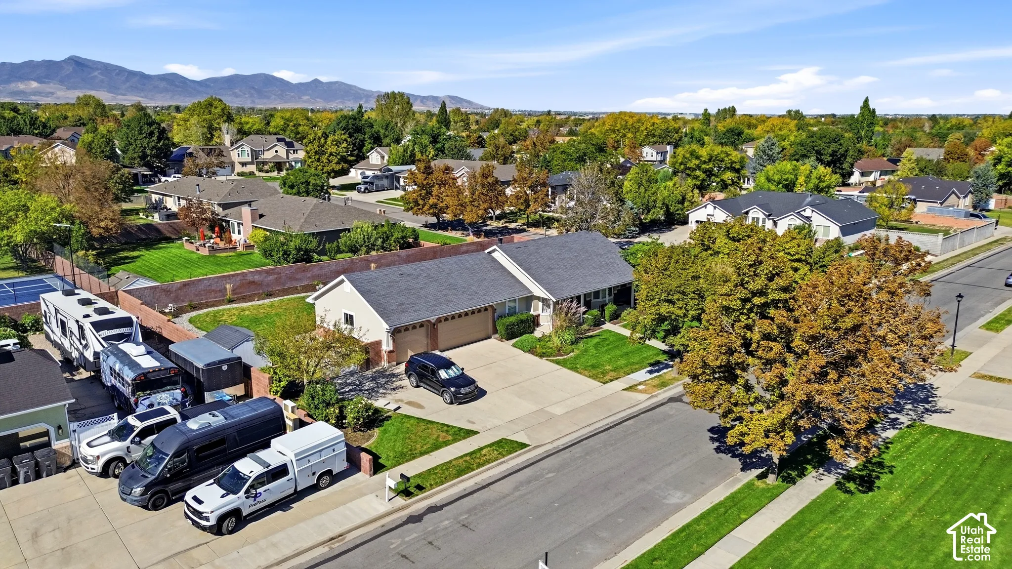 Single-story residence with an attached two-car garage, mature landscaping, and a paved driveway