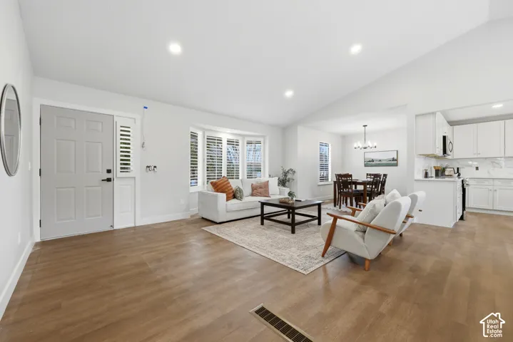 Wood-finish flooring throughout, recessed lighting, and a vaulted ceiling