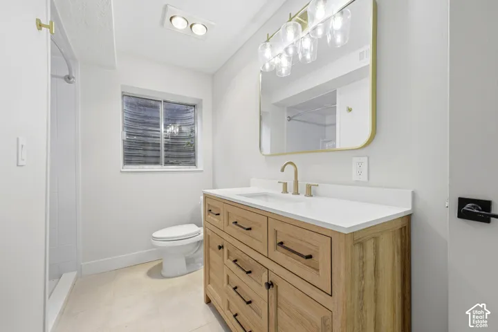 Wood-finish vanity with a white countertop and gold-tone faucet