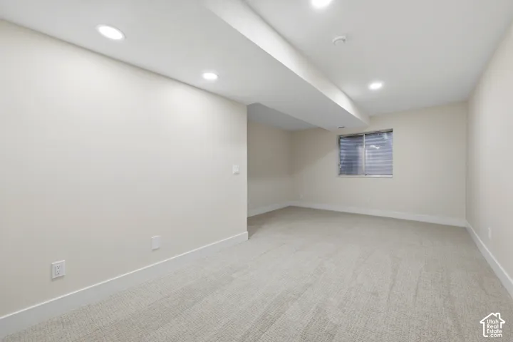 Recessed lighting, light-toned carpeting, window with blinds, and neutral wall tones