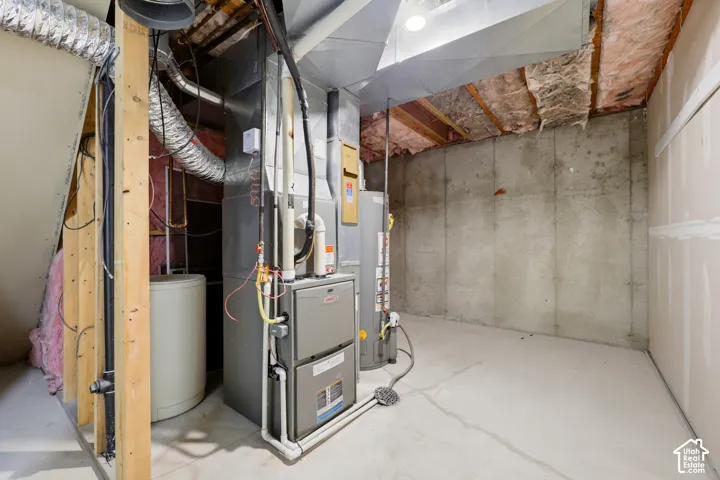 Concrete foundation walls, exposed ceiling joists, and a utility area with mechanical systems