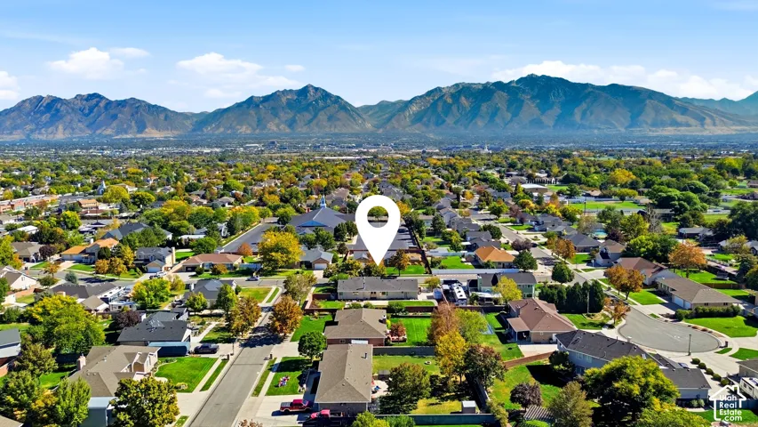 Suburban neighborhood with mature trees, residential streets, and a mountainous backdrop