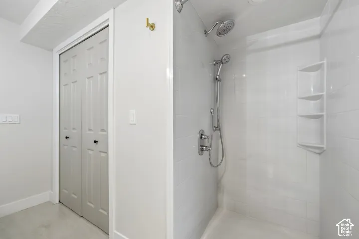 Walk-in shower with white subway tile surround and integrated shelving