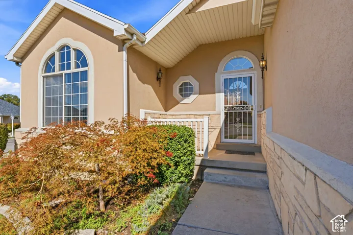 Stucco exterior with stone accent siding, arched window, and front porch