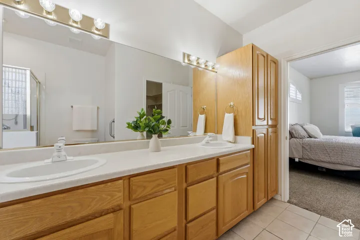 Primary en suite with dual sink vanity and wood-finish cabinetry