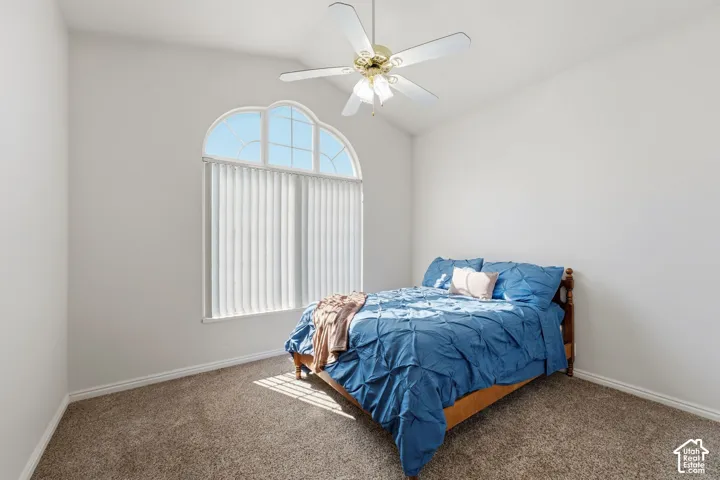 Bedroom #2 featuring arched window, carpeted floors, and ceiling fan