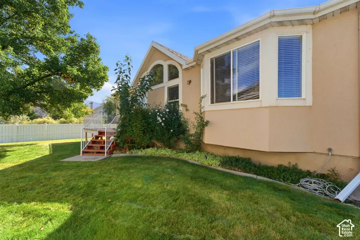 Back lawn area with wood deck and white railing