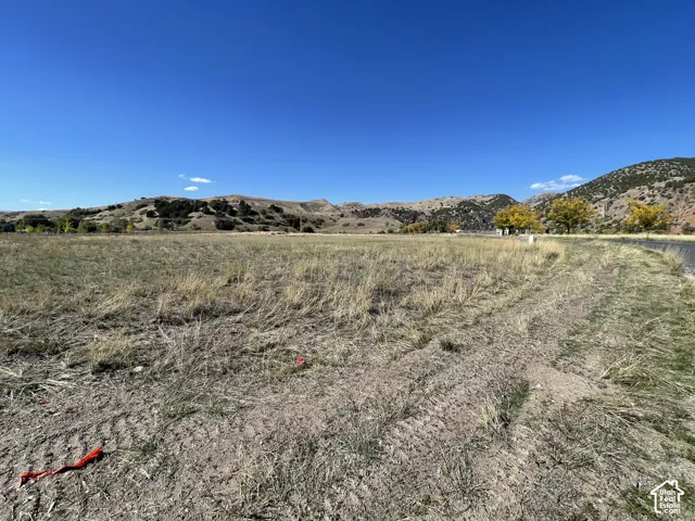 Expansive undeveloped land featuring natural terrain and distant rolling hills