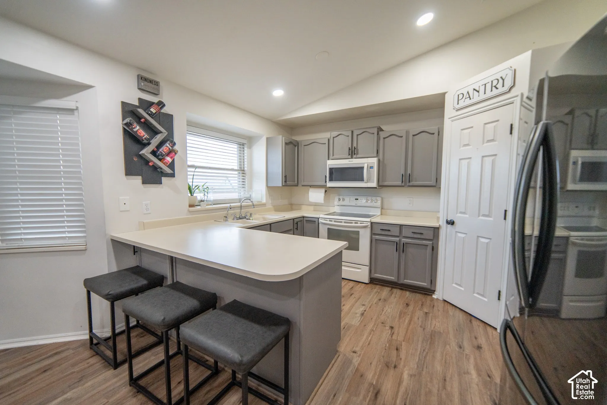 Kitchen featuring wood-finish flooring, recessed lighting, light-toned countertops, and gray cabinetry
