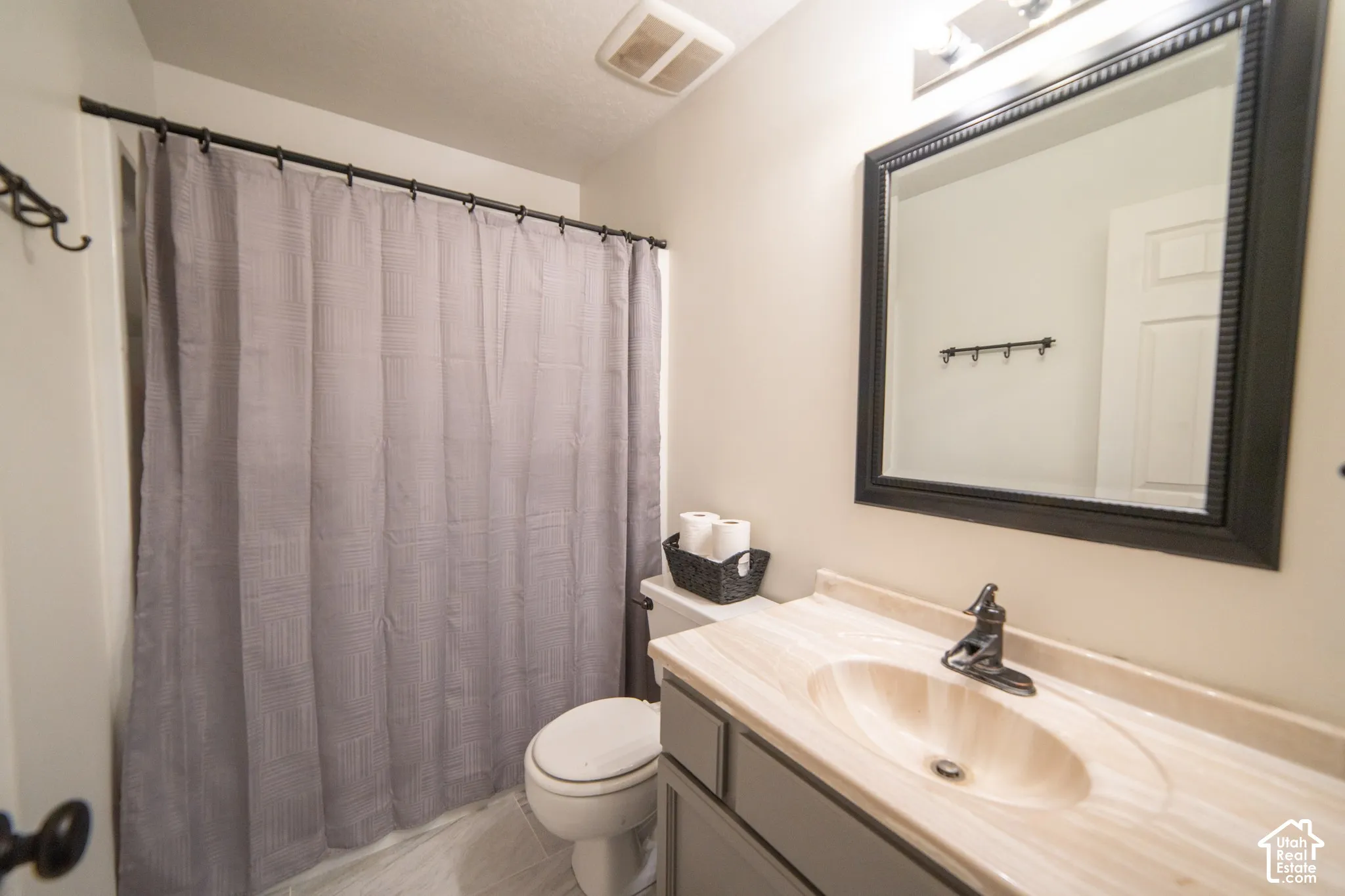 Vanity with integrated sink, framed mirror, and mounted light fixture