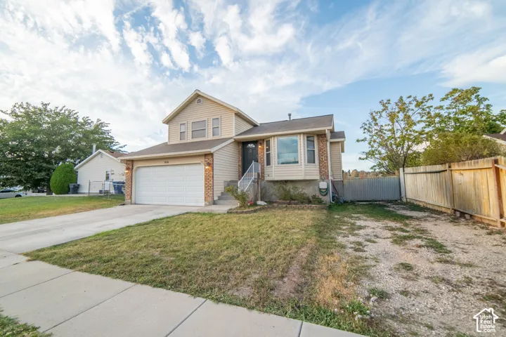Two-story residence featuring a two-car garage, bay window, and a fenced side yard