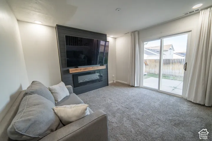 Wall-mounted electric fireplace with wood mantel, built-in media center, and sliding glass door
