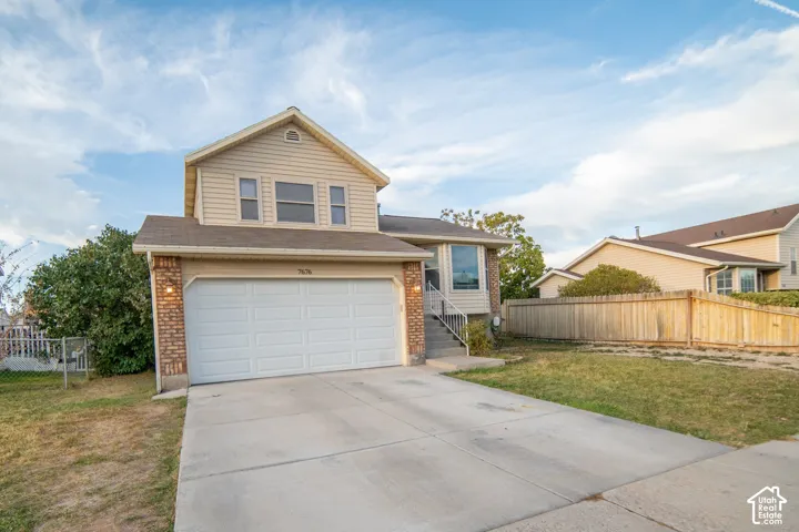Two-story residence featuring siding and brick accents, an attached two-car garage, and a concrete driveway