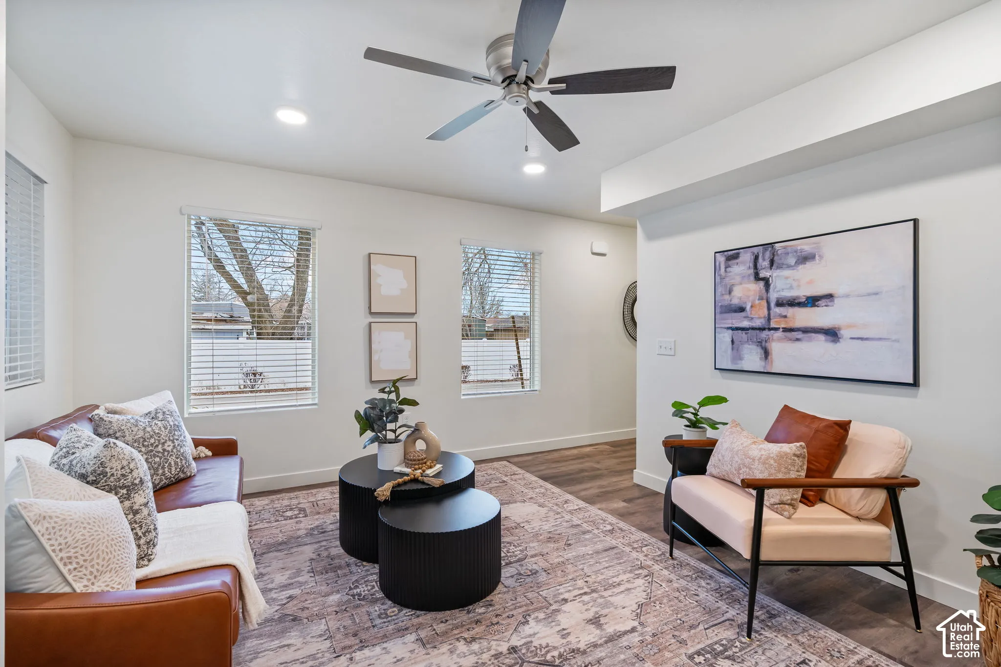 Wood-finish flooring throughout, recessed lighting, ceiling fan, multiple windows with blinds, and neutral wall tones