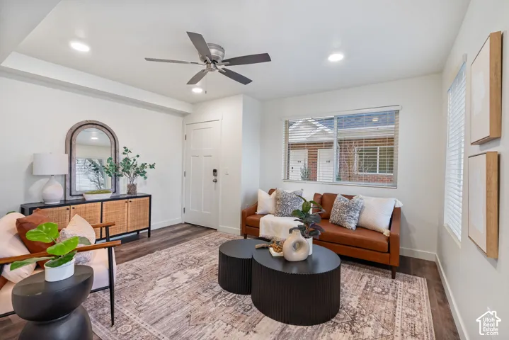 Recessed lighting, wood-finish flooring, ceiling fan, white paneled entry door, and a horizontal window with blinds