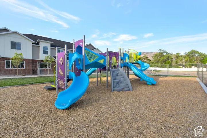 Community playground featuring wood chip surfacing, multiple slides, and integrated climbing elements