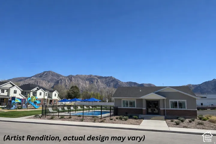 Community clubhouse featuring a swimming pool, playground, and mountain backdrop