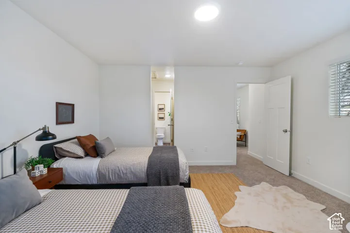 Neutral white walls with recessed ceiling lighting, a privacy window with blinds, and light-toned carpet flooring