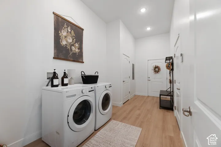 Extra Large Dedicated laundry area with front-loading appliances, wood-finish flooring, recessed lighting, and white paneled doors