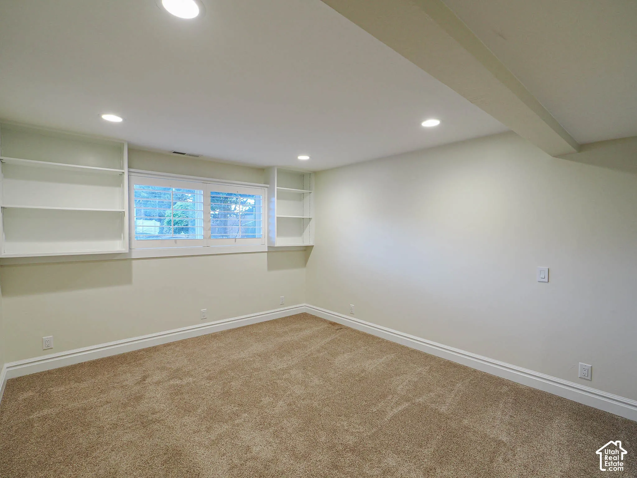Recessed ceiling lighting, built-in shelving, window with horizontal blinds, carpeted flooring, and crown molding