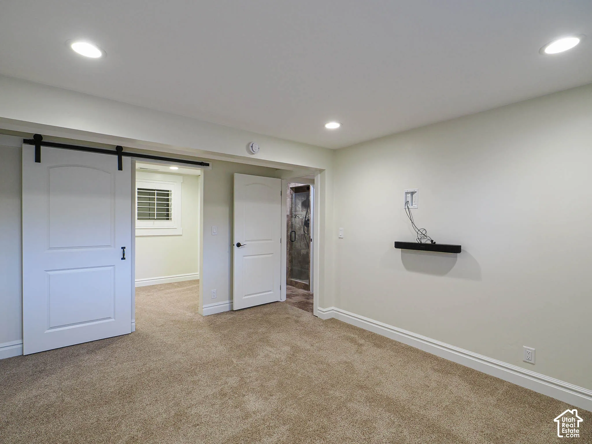Recessed lighting, carpet flooring, a barn door, and a built-in wall shelf