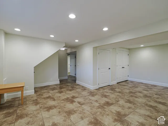 Recessed lighting, tile flooring, interior doors with dark hardware, and painted walls
