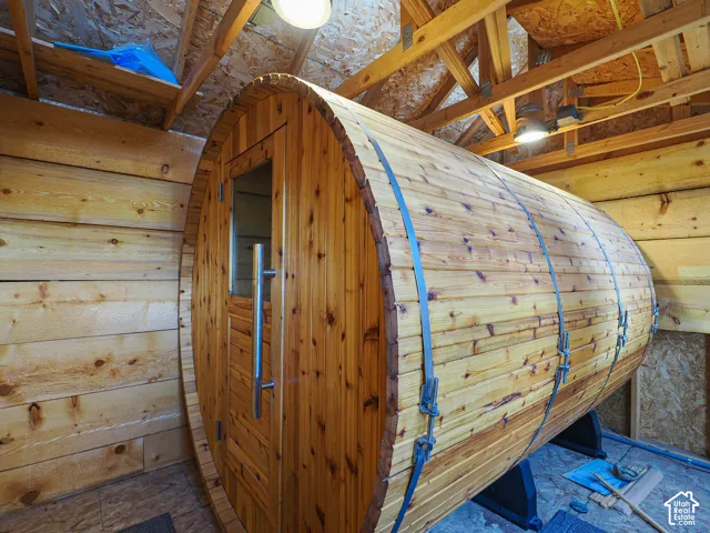 Barrel-shaped sauna with a wood-plank exterior and a clear-paneled door with a metal handle