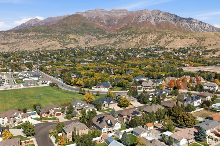 Residential area with varied architectural styles, green spaces, and mountain backdrop