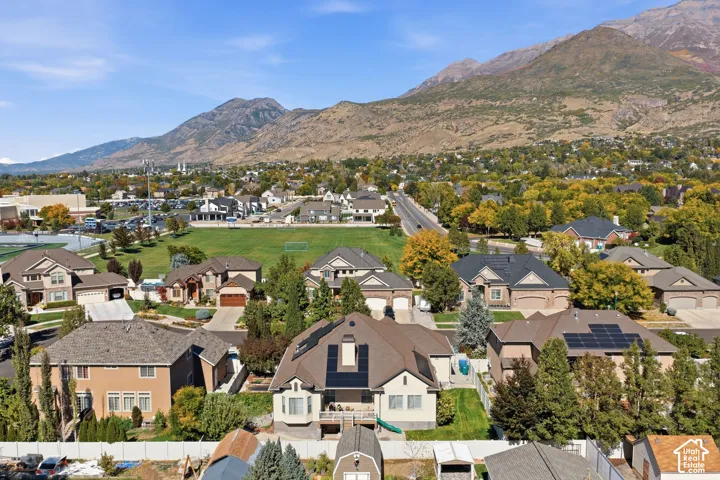 Residential neighborhood with varied house styles and mature trees, featuring prominent mountain scenery