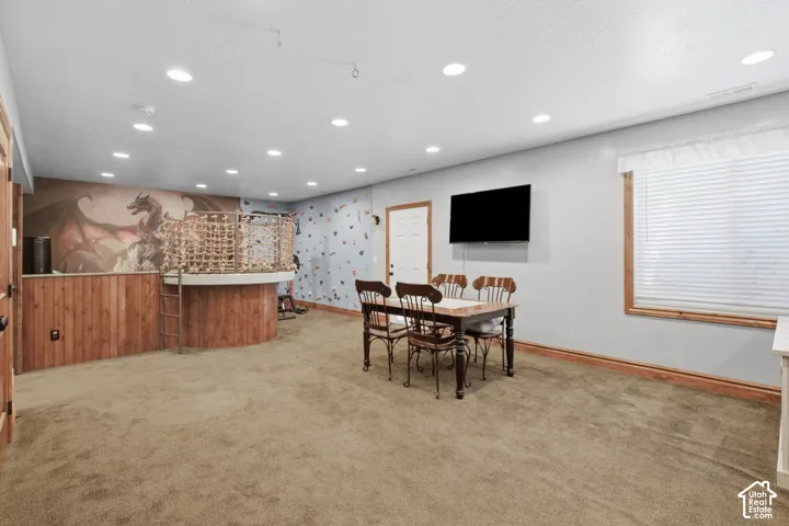 Recessed lighting, light-colored walls, wood-paneled accents, and a window with blinds