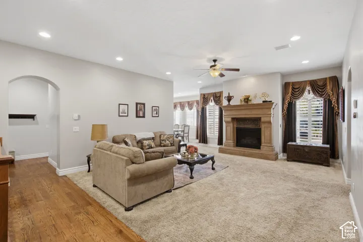Spacious living area featuring a prominent fireplace, recessed lighting, ceiling fan, and arched entryway