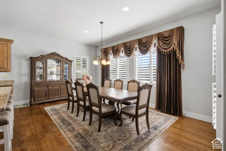 Hardwood flooring, recessed ceiling lighting, and a multi-light pendant fixture