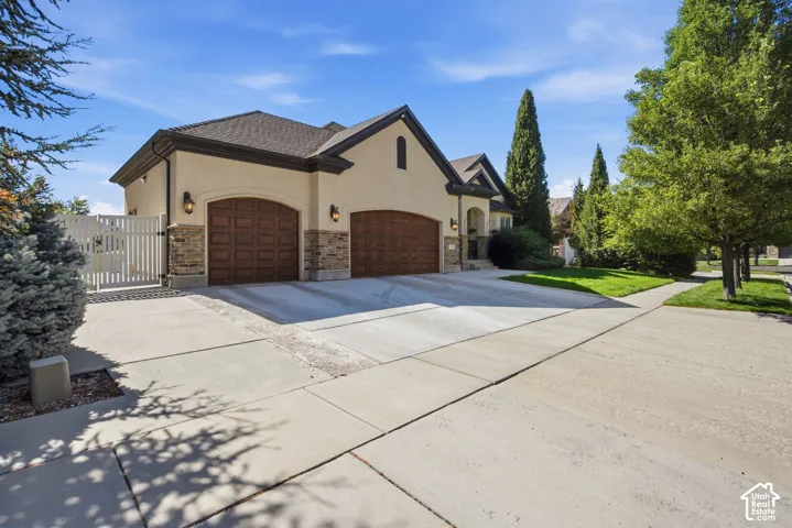 Stucco exterior with stone accents and arched garage doors