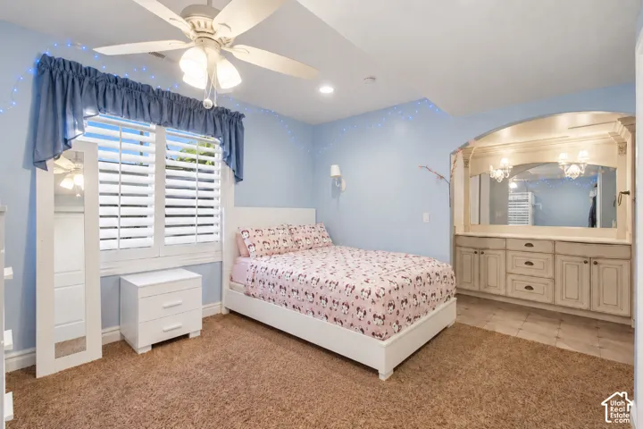 Recessed vanity with dual sconce lighting, built-in cabinetry, and tile flooring