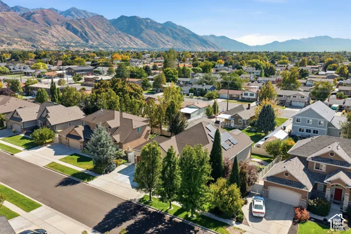 Expansive residential area with a prominent mountainous backdrop, featuring a mix of mature trees and established landscaping