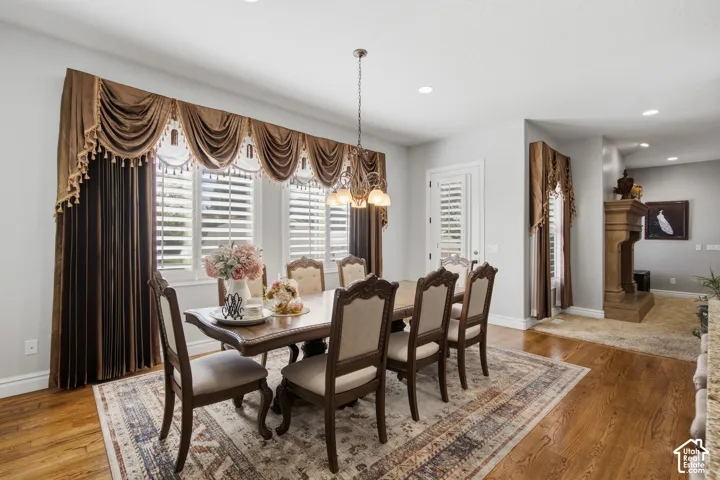 Hardwood flooring extends throughout this space, complemented by a decorative chandelier