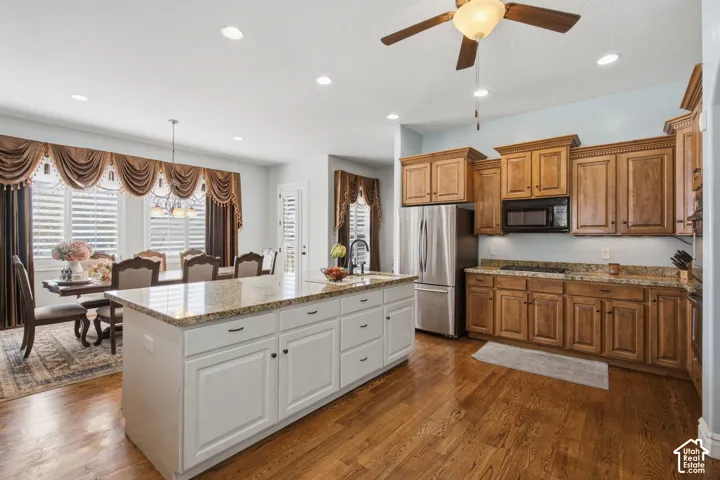 Expansive kitchen island with a granite countertop and white cabinetry