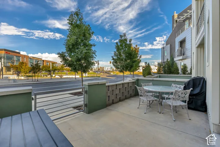 Concrete patio area with a privacy wall, integrated block fencing, and a metal-barred gate