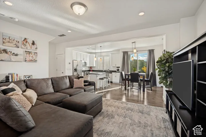 Open-concept living space featuring wood-finish flooring and recessed lighting