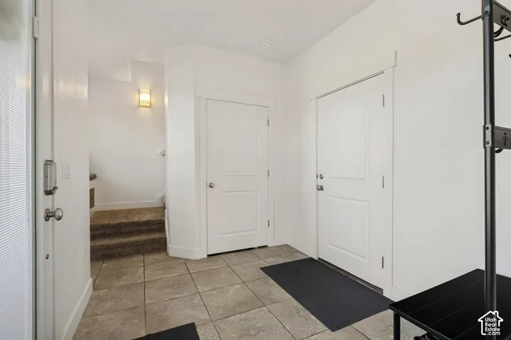 Tiled entry flooring, paneled interior doors, and a wall-mounted sconce