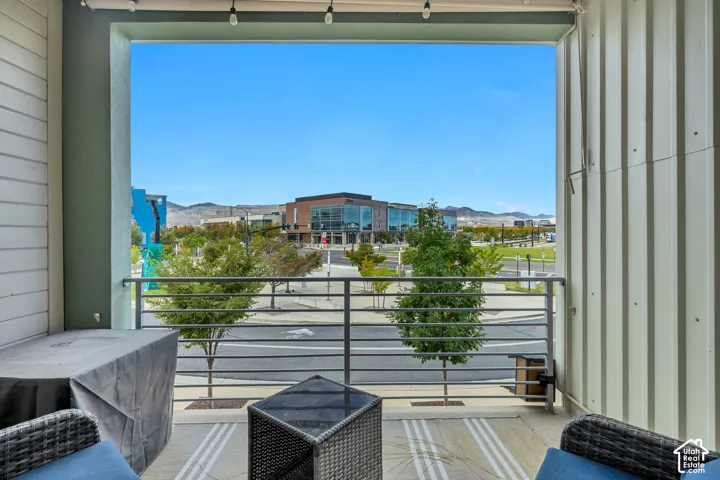 Outdoor balcony with a horizontal metal railing and string lights