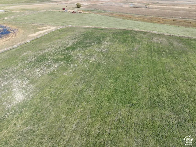 Expansive open fields with varied green foliage and distant land features