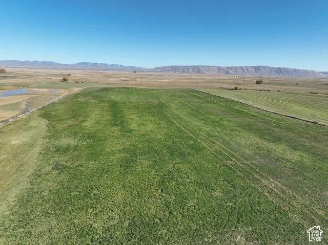 Expansive cultivated land with distant mountain ranges and a clear blue sky