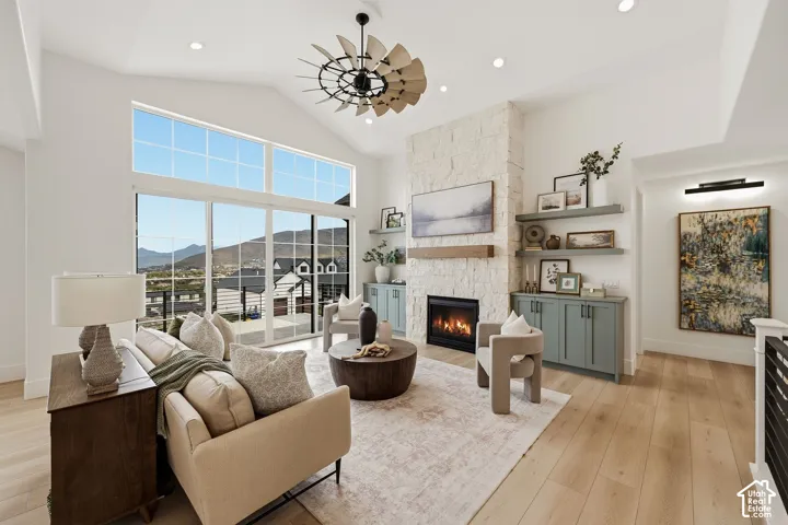 Living room with vaulted ceilings, oversized slider doors, stone fireplace and custom built ins.
